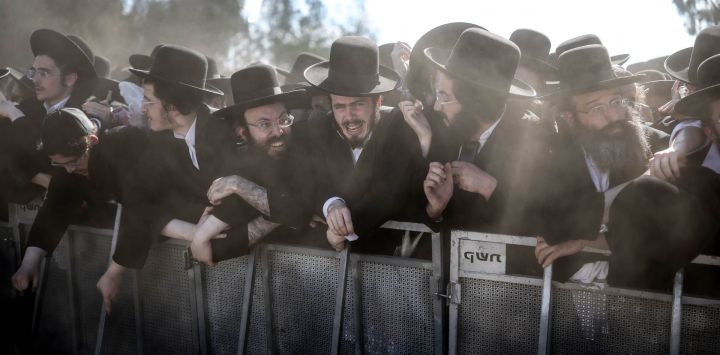 Judíos ultraortodoxos reaccionan tras una barrera durante una protesta contra el servicio militar obligatorio frente a la prisión militar de Bet Lid en Kfar Yona. Los legisladores israelíes votaron a favor de un proyecto de ley que permitiría a la mayoría de los hombres judíos ultraortodoxos evitar el servicio militar obligatorio, a pesar de las fuertes protestas de la oposición. Si bien los hombres ultraortodoxos han estado exentos del servicio militar en gran medida a lo largo de la historia moderna de Israel, el Tribunal Supremo ha cuestionado repetidamente esta situación en los últimos años, culminando en un fallo de 2024 que obliga al gobierno a reclutarlos.