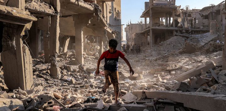 Un niño camina entre los escombros de un edificio destruido tras un bombardeo israelí después de una orden de evacuación, en el campamento de refugiados palestinos de Maghazi, en el centro de la Franja de Gaza. Gaza sigue sumida en la violencia diaria a pesar del alto el fuego formal vigente desde octubre de 2025, y tanto el ejército israelí como Hamás se acusan mutuamente de violar la tregua.