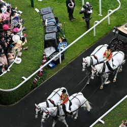 El rey Carlos III y la reina Camila de Gran Bretaña llegan en carruaje tirado por caballos el tercer día del hipódromo Royal Ascot en Ascot, al oeste de Londres. | Foto:JUSTIN TALLIS / AFP