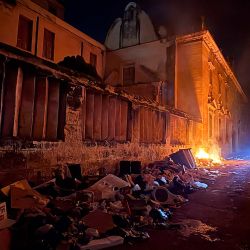 Un motociclista pasa junto a una pila de basura en llamas durante un apagón en La Habana, Cuba. | Foto:PABLO PORCIUNCULA / AFP