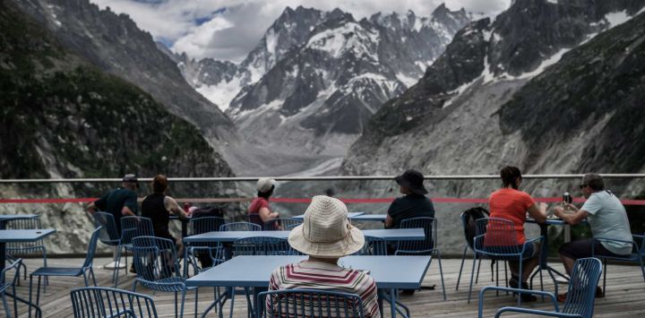 Turistas contemplan el macizo del Mont Blanc y el glaciar "Mer de Glace" en la estación de Montenvers, en los Alpes franceses, en el centro-este de Francia.