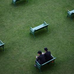 Los asistentes a las carreras se relajan antes del inicio de las mismas en el quinto día del encuentro hípico Royal Ascot, en Ascot, al oeste de Londres, Inglaterra. | Foto:HENRY NICHOLLS / AFP