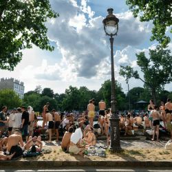 Los bañistas toman el sol en las orillas del Canal Saint-Martin, en un lugar no autorizado para nadar, mientras Francia sufre una ola de calor en París. Francia emitió una alerta roja por ola de calor en más de un tercio del país debido a la intensa ola de calor y a la prohibición del consumo de alcohol en ciertas áreas durante las festividades anuales de la Fête de la Musique. | Foto:ARNAUD FINISTRE / AFP