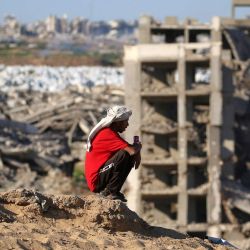 Un hombre se sienta en la cima de una colina cerca de edificios destruidos y gravemente dañados en el campamento de refugiados palestinos de Nuseirat, en el centro de la Franja de Gaza. | Foto:Eyad Baba / AFP