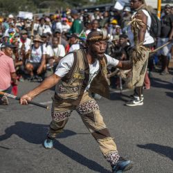 Un manifestante vestido con atuendo tradicional zulú hace un gesto durante una protesta de miembros del Movimiento «Marcha y Marcha» en el municipio de Umlazi, al suroeste de Durban, Sudáfrica. | Foto:RAJESH JANTILAL / AFP