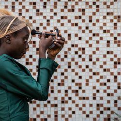 Una dama de honor se prepara para la ceremonia nupcial de los hermanos gemelos Taiwo y Kehinde Oguntoye y las hermanas gemelas Taiwo y Kehinde Adediran en la Iglesia Anglicana Memorial del Obispo Akinyele en Ibadan, Nigeria. | Foto:OLYMPIA DE MAISMONT / AFP