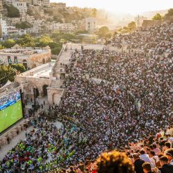 Aficionados jordanos se congregan para ver en pantallas gigantes el partido de fútbol de su selección nacional contra Argelia en el Grupo J del Mundial de 2026, en el anfiteatro romano del siglo II de Amán. | Foto:George Saif / AFP