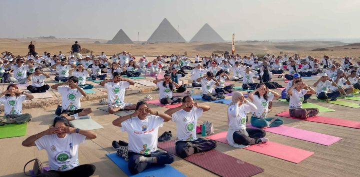 Personas participantes en una sesión de yoga para celebrar el Día Internacional del Yoga en el punto escénico de las Pirámides de Giza, en Giza, Egipto.