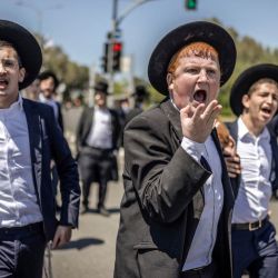 Judíos ultraortodoxos, en su mayoría exentos del servicio militar, protestan contra el reclutamiento obligatorio a la entrada de Tel Hashomer, el centro de reclutamiento del ejército israelí, en Ramat-Gan. El primer ministro de Israel, que depende de sus aliados del partido ultraortodoxo para mantenerse en el poder, ha empleado diversas tácticas para retrasar la aprobación de la legislación que permitiría el alistamiento de los judíos ultraortodoxos, quienes gozan de una amplia exención del servicio militar. Según una normativa establecida en la creación del país en 1948 —cuando la comunidad ultraortodoxa era pequeña—, los hombres que se dedican a tiempo completo al estudio de los textos sagrados judíos reciben una exención de facto. | Foto:ilia yefimovich / AFP