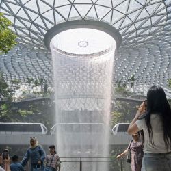 Personas tomaron fotografías de la cascada artificial interior Rain Vortex en el aeropuerto Jewel Changi, en Singapur. | Foto:Xinhua/Then Chih Wey