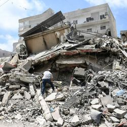 Un hombre camina sobre los escombros mientras busca objetos en un edificio alcanzado por ataques militares israelíes en un barrio de la ciudad costera de Tiro, en el sur del Líbano, los mediadores Pakistán y Qatar anunciaron que Teherán y Washington habían acordado establecer una "célula de desescalada" para limitar los brotes de violencia en el Líbano tras las conversaciones celebradas en Suiza para poner fin a la guerra en Oriente Medio. | Foto:Joseph Eid / AFP
