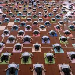Varias personas participan en una sesión de yoga para celebrar el Día Internacional del Yoga en el Estadio Cubierto Thuwanna en Yangon, Myanmar. | Foto:Sai Aung Main / AFP