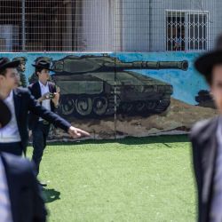 Judíos ultraortodoxos, en su mayoría exentos del servicio militar, se congregan durante una protesta contra el reclutamiento obligatorio en la entrada de Tel Hashomer, el centro de reclutamiento del ejército israelí, en Ramat-Gan. El primer ministro de Israel, que depende de sus aliados del partido ultraortodoxo para mantenerse en el poder, ha empleado diversas tácticas para retrasar la aprobación de la legislación que permitiría el alistamiento de los judíos ultraortodoxos, quienes gozan de una amplia exención del servicio militar. Según una normativa establecida en la creación del país en 1948 —cuando la comunidad ultraortodoxa era pequeña—, los hombres que se dedican a tiempo completo al estudio de los textos sagrados judíos reciben una exención de facto. | Foto:ilia yefimovich / AFP
