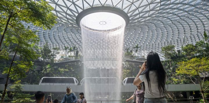 Personas tomaron fotografías de la cascada artificial interior Rain Vortex en el aeropuerto Jewel Changi, en Singapur.