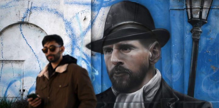Un hombre camina cerca de un mural que representa al astro del fútbol argentino Lionel Messi en Buenos Aires.