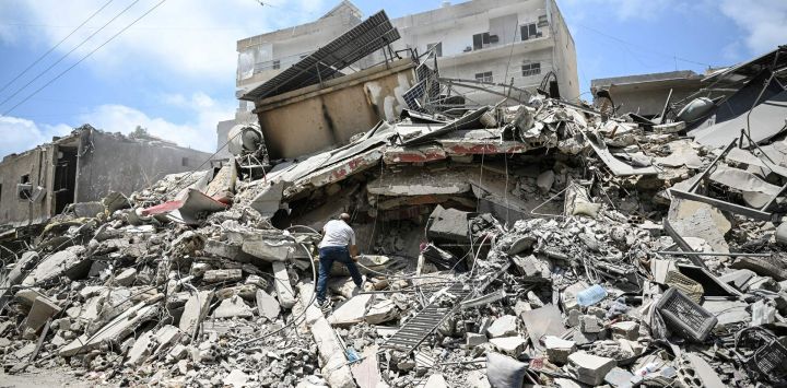 Un hombre camina sobre los escombros mientras busca objetos en un edificio alcanzado por ataques militares israelíes en un barrio de la ciudad costera de Tiro, en el sur del Líbano, los mediadores Pakistán y Qatar anunciaron que Teherán y Washington habían acordado establecer una "célula de desescalada" para limitar los brotes de violencia en el Líbano tras las conversaciones celebradas en Suiza para poner fin a la guerra en Oriente Medio.