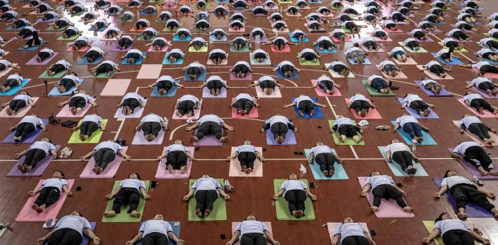Varias personas participan en una sesión de yoga para celebrar el Día Internacional del Yoga en el Estadio Cubierto Thuwanna en Yangon, Myanmar.