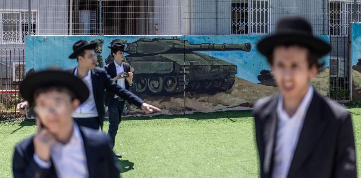 Judíos ultraortodoxos, en su mayoría exentos del servicio militar, se congregan durante una protesta contra el reclutamiento obligatorio en la entrada de Tel Hashomer, el centro de reclutamiento del ejército israelí, en Ramat-Gan. El primer ministro de Israel, que depende de sus aliados del partido ultraortodoxo para mantenerse en el poder, ha empleado diversas tácticas para retrasar la aprobación de la legislación que permitiría el alistamiento de los judíos ultraortodoxos, quienes gozan de una amplia exención del servicio militar. Según una normativa establecida en la creación del país en 1948 —cuando la comunidad ultraortodoxa era pequeña—, los hombres que se dedican a tiempo completo al estudio de los textos sagrados judíos reciben una exención de facto.
