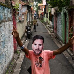 Un aficionado con una máscara del futbolista argentino Lionel Messi baila en Calcuta, India. | Foto:DIBYANGSHU SARKAR / AFP