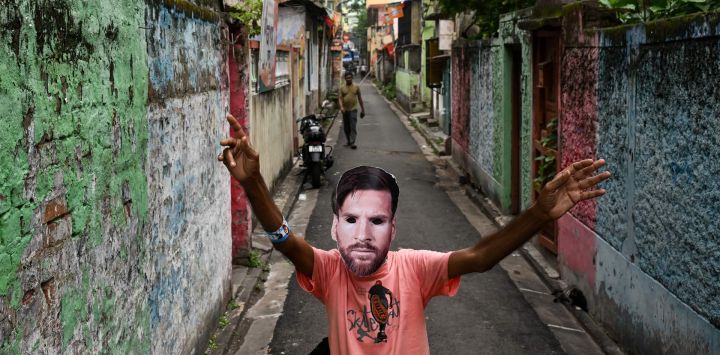 Un aficionado con una máscara del futbolista argentino Lionel Messi baila en Calcuta, India.