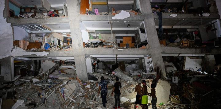 Varias personas permanecen entre los escombros cerca de un edificio dañado tras el terremoto en Catia La Mar, estado La Guaira, a unos 30 km al noroeste de Caracas, Venezuela.