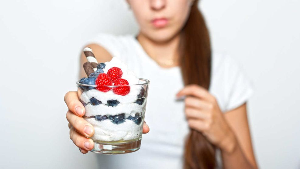 Persona desayunando yogur con  cereales y frutas 26062026