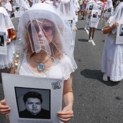 Activistas de “Gays Against Guns” sostienen fotografías de víctimas mientras marchan por los derechos LGBTQ durante la Marcha del Orgullo de la Ciudad de Nueva York. | Foto:KENA BETANCUR / AFP
