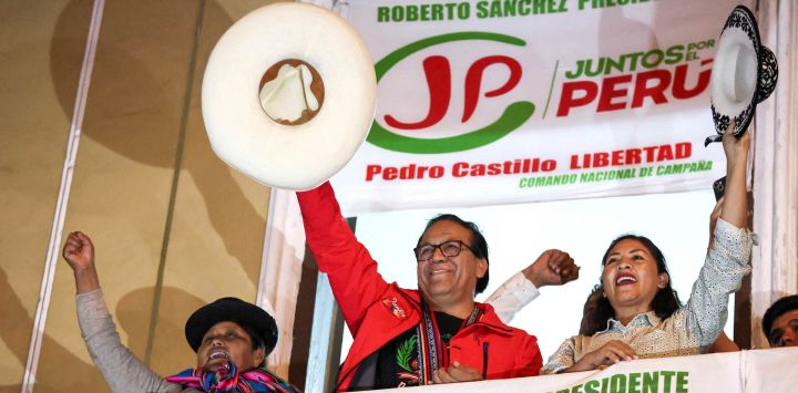 Roberto Sánchez, candidato presidencial del partido Juntos por el Perú, saluda a sus simpatizantes flanqueado por su primera candidata a la vicepresidencia, Anali Márquez (derecha), y su segunda candidata a la vicepresidencia, Brígida Curo, durante una marcha de protesta en Lima. Sánchez encabezó una marcha que exigía transparencia en el recuento de votos de la segunda vuelta, cuando se encontraba ligeramente por detrás de la candidata de derecha Keiko Fujimori.