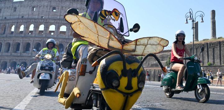 Aficionados a la Vespa de todo el mundo participan en el desfile de los Vespa World Days, que conmemora el 80 aniversario de la emblemática marca italiana de scooters, en Roma.