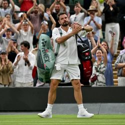 El suizo Stan Wawrinka saluda al público al retirarse tras su derrota ante el italiano Matteo Berrettini en el partido de primera ronda individual masculino de tenis, disputado el segundo día del Campeonato de Wimbledon 2026 en el All England Lawn Tennis and Croquet Club de Wimbledon, al suroeste de Londres. | Foto:Glyn Kirk / AFP