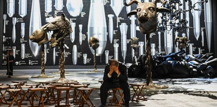 El artista chino Ai Weiwei posa con una de sus nuevas obras titulada «Historia de las bombas», durante una sesión fotográfica para promocionar su próxima exposición «Ai Weiwei: ¡Abotónate!», en los estudios Aviva de Manchester, al norte de Inglaterra.
