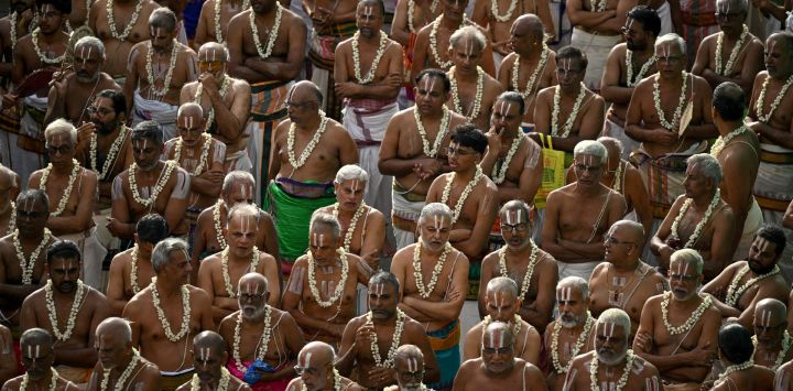 Un grupo de sacerdotes participa recitando mantras en una procesión con carrozas en el templo Sri Parthasarthy en Chennai, India.