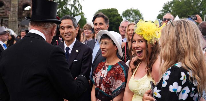 Un invitado imita al rey Carlos III de Gran Bretaña durante una fiesta en los jardines del Palacio de Holyroodhouse en Edimburgo, Escocia.