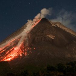 La lava y los flujos piroclásticos brotan de la cima del monte Merapi durante una erupción, tal como se observa desde la aldea de Ngori, en Java Central, Indonesia. | Foto:DEVI RAHMAN / AFP)