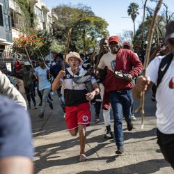 Los manifestantes corren detrás de personas que creen que son extranjeros indocumentados durante una manifestación de los movimientos "Marcha y Marcha" y Operación Dudula que marcan una fecha límite no oficial establecida por grupos liderados por ciudadanos para que los extranjeros indocumentados abandonen Sudáfrica, en Johannesburgo. | Foto:EMMANUEL CROSET / AFP