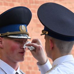 Un miembro de la guardia de honor seca el sudor del rostro de su compañero junto a la Llama Eterna en el Jardín de Alejandro, en el centro de Moscú. La agencia meteorológica rusa emitió una alerta por calor con temperaturas diurnas que se esperaban alcanzaran los 31 grados Celsius. | Foto:Igor Ivanko / AFP