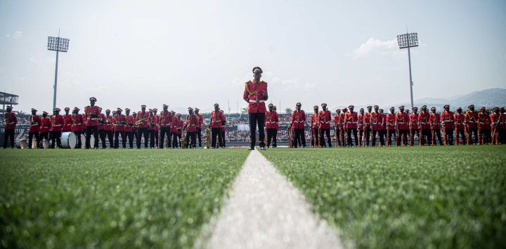 Miembros de la banda militar de las fuerzas de seguridad de Burundi, ataviados con sus uniformes de gala rojos, forman en el campo durante las celebraciones oficiales del 64.º aniversario de la Independencia de Burundi en el Estadio Intwari de Buyumbura.