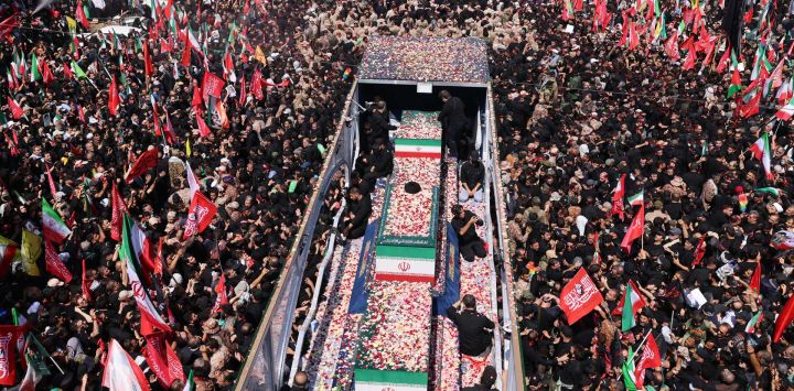 Pétalos de flores son arrojados sobre los ataúdes del asesinado líder supremo de Irán, Ali Khamenei, y sus familiares a lo largo de una calle durante su cortejo fúnebre en Teherán.
