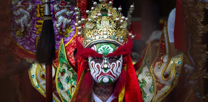 Un artista, vestido como un guardián de Na Tcha, espera el inicio de las celebraciones de la Fiesta de Na Tcha en Macao, China. La Fiesta de Na Tcha es un vibrante festival taoísta anual que se celebra en Macao y que conmemora el nacimiento de la deidad infantil Na Tcha.