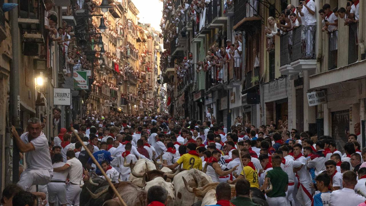 Los participantes corren delante de los toros de la ganadería Fuente Ymbro durante el primer encierro de las fiestas de San Fermín en Pamplona, norte de España. Miles de personas asisten cada año a las fiestas, que duran una semana, y a sus famosos encierros, en los que seis toros son liberados a las 8:00 de la mañana para correr desde su corral hasta la plaza de toros por las estrechas calles del casco antiguo, recorriendo una distancia de 850 metros. Los corredores que van delante intentan mantenerse cerca de los toros sin caerse ni ser corneados. | Foto:JORGE GUERRERO / AFP