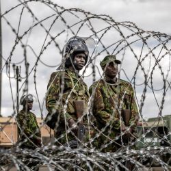 Agentes de la policía antidisturbios keniana montan guardia tras una barricada de alambre de púas mientras las autoridades imponen controles de carretera y el cierre parcial de las principales vías durante la marcha prevista de Saba Saba en el centro de Nairobi. La policía keniana prohibió la marcha, que conmemoraba un día anual de protesta, utilizando agentes de paisano y vehículos sin distintivos para dispersar incluso al pequeño grupo que logró reunirse. | Foto:LUIS TATO / AFP