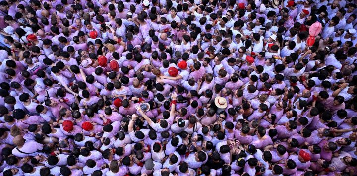 Los juerguistas participan en el 'Chupinazo' (lanzamiento de cohetes) que marca el inicio oficial del Festival de San Fermín en la Plaza Consistorial frente al Ayuntamiento de Pamplona, en el norte de España.