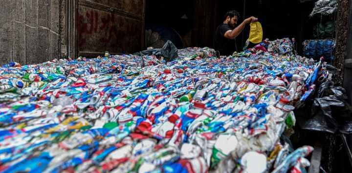 Un trabajador egipcio prepara plástico para su procesamiento en una planta de reciclaje en el vertedero del barrio de Manshiyet Nasser, en El Cairo.