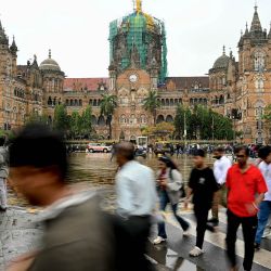 Esta fotografía muestra a peatones cruzando una calle para acceder a una acera cerca de la estación de tren Chhatrapati Shivaji Maharaj Terminus (CSMT) en Bombay. En India, una acera puede tener muchos usos —como un puesto ambulante, un aparcamiento o un vertedero—, pero rara vez cumple su función original: ser un camino seguro y despejado para caminar. | Foto:Indranil Mukherjee / AFP