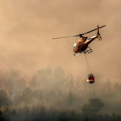 Esta fotografía muestra un helicóptero Airbus Helicopters H125 de bomberos sobrevolando un incendio forestal en Pouzols-Minervois, al suroeste de Francia. Cientos de bomberos luchan contra los incendios forestales en el sur del país, avivados por el viento, la sequía y el calor. El incendio más grande se encuentra en el departamento de Aude, pero también hay incendios al norte de Marsella, donde se espera que el Primer Ministro presida un nuevo grupo de trabajo interministerial para la crisis. | Foto:IDRISS BIGOU-GILLES / AFP