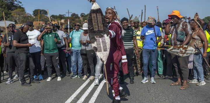 Manifestantes con atuendos tradicionales corean consignas durante una protesta del movimiento "Marcha y Marcha" en Mtwalume, al sur de Durban. El grupo ya había organizado marchas a nivel nacional y ha instado a sus seguidores a seguir manifestándose. El movimiento exige al gobierno que aplique medidas más estrictas contra la inmigración ilegal y que deporte a los extranjeros indocumentados.