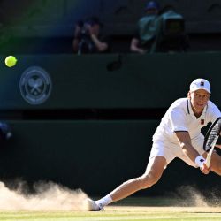 El italiano Jannik Sinner resbala en el suelo al devolver la pelota al alemán Alexander Zverev durante la final individual masculina de tenis, en la decimocuarta jornada del Campeonato de Wimbledon 2026, en el All England Lawn Tennis and Croquet Club de Wimbledon, al suroeste de Londres. | Foto:KIRILL KUDRYAVTSEV / AFP