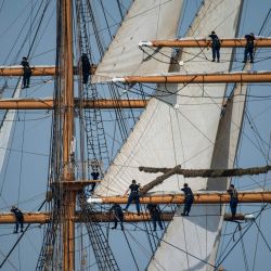 La tripulación del USCGC Eagle trepa por el aparejo durante el desfile náutico Sail Boston Parade of Sail en el puerto de Boston, Massachusetts. | Foto:Joseph Prezioso / AFP