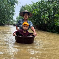 Un residente camina entre las aguas de la inundación con un niño en una bañera, que utilizaba un dispositivo de flotación, en Kyauktaw, estado de Rakhine, al oeste de Myanmar. | Foto:AFP