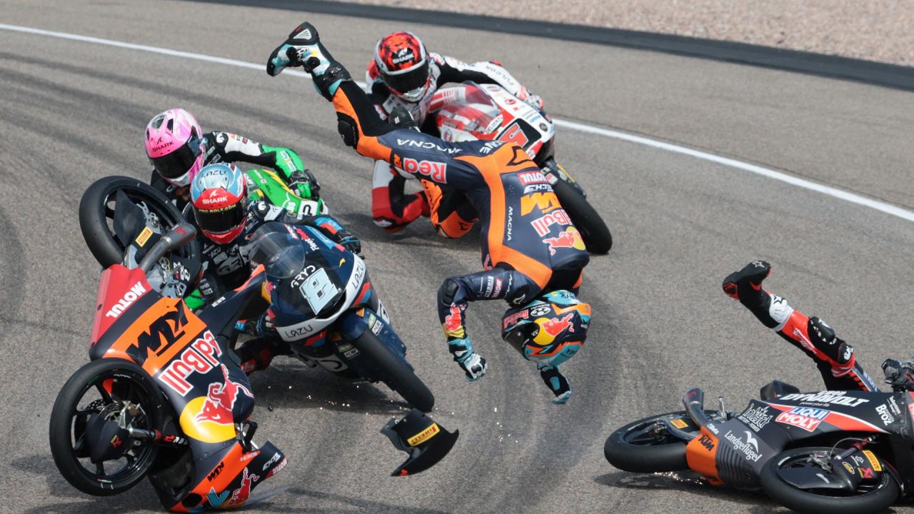 El piloto argentino Valentín Perrone (C, volando por los aires) y el piloto español Marcos Uriarte (D, cayendo en la pista), del equipo Red Bull KTM Tech3, sufren un accidente durante la carrera de Moto3 en el circuito de Sachsenring, en Hohenstein-Ernstthal, cerca de Chemnitz, al este de Alemania, antes del Gran Premio de Alemania de MotoGP. | Foto:RONNY HARTMANN / AFP